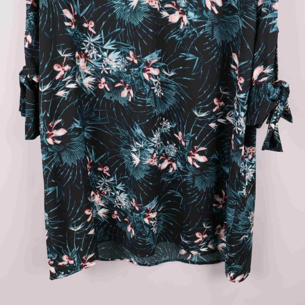 Närbild på nederdel av klänningen som visar knytbandsdetalj