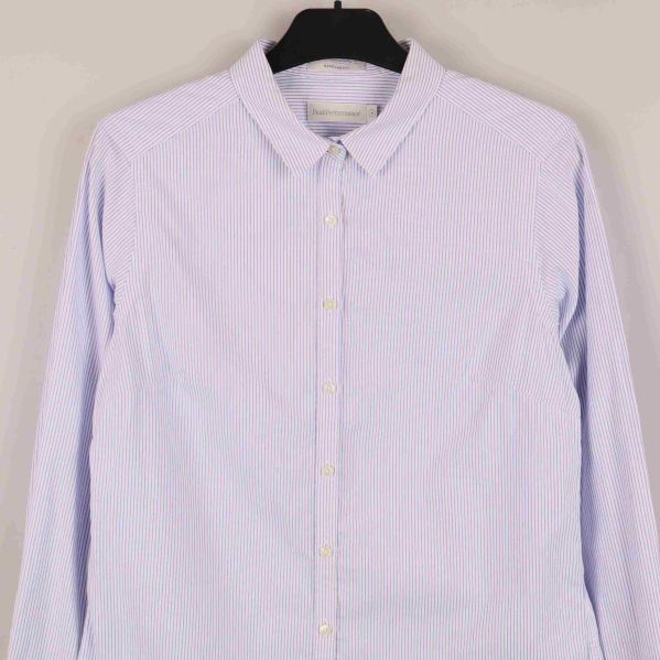 Närbild på skjortans överdel och knappslå framifrån