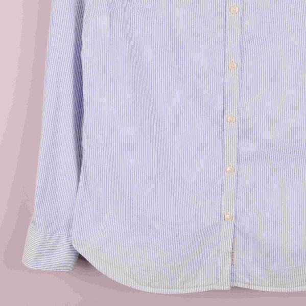 Närbild på skjortans nederdel och knappslå på höger sida