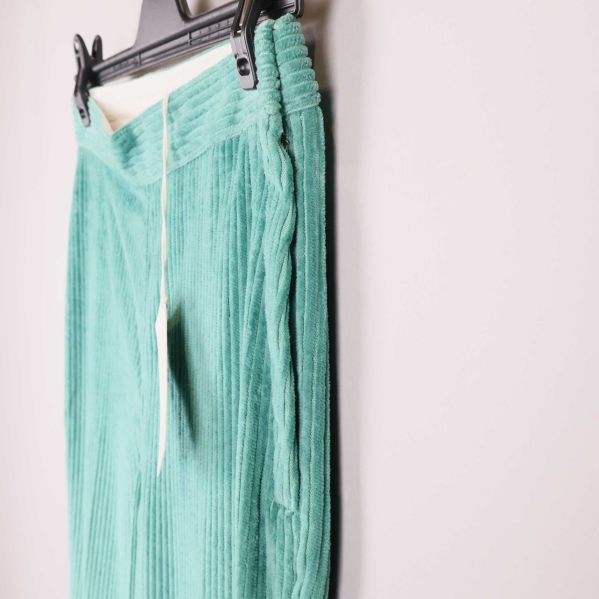 Sidovy på gröna byxor med synlig resår och struktur