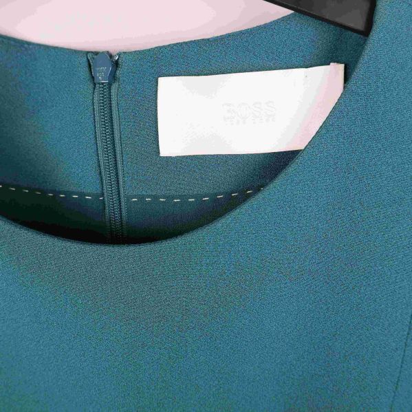 Närbild på halsringningen och märkning i klänningen