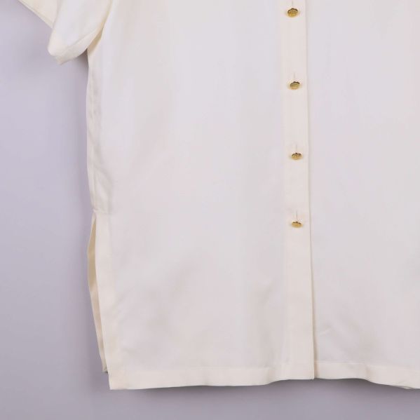 Nedre del av vit skjorta med sidslits och knappslå