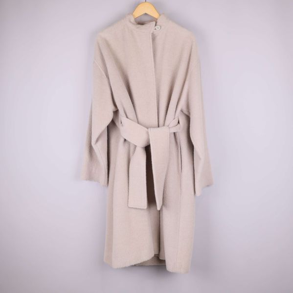 Ljusbeige kappa med bälte hängande 