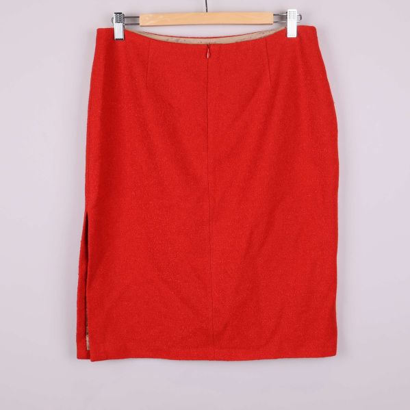 Baksidan av röd kjol med sprund i sidan och dragkedja