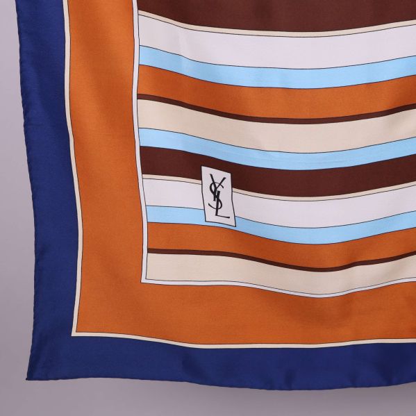 Närbild på scarfens hörn och YSL-logga