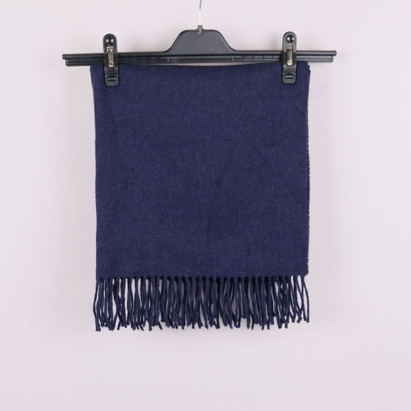 Blå halsduk vikt med fransar synliga upptill