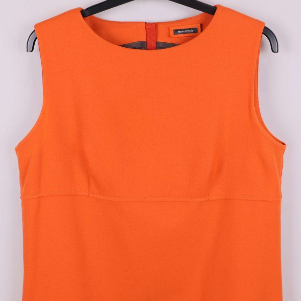 Närbild på överdelen av orange ärmlös klänning