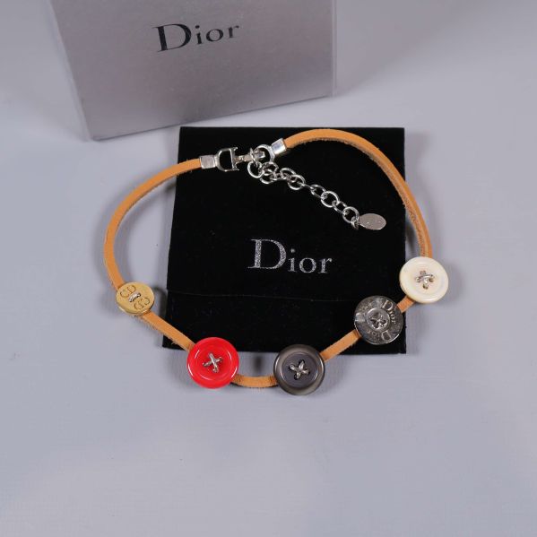 Dior halsband med knappdetaljer och ask i bakgrunden