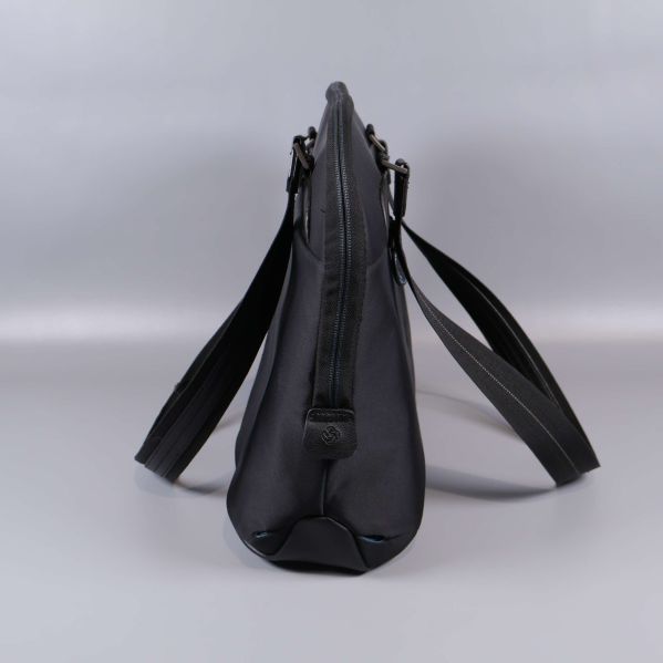 Smal profilvy på svart datorväska i tyg och läder