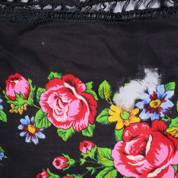 Närbild av blommig sjal med synlig slitage