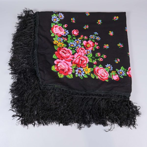 Uppvikt sjal med rikligt blommönster och fransar