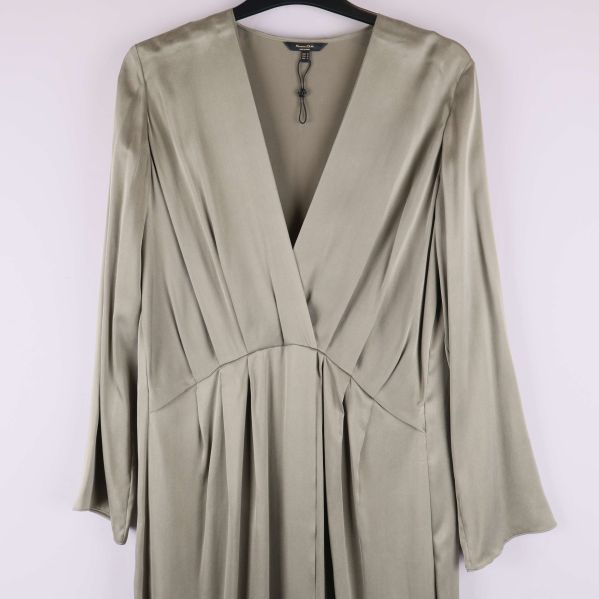 Närbild framtill på klänningens veck och djupa V-ringning