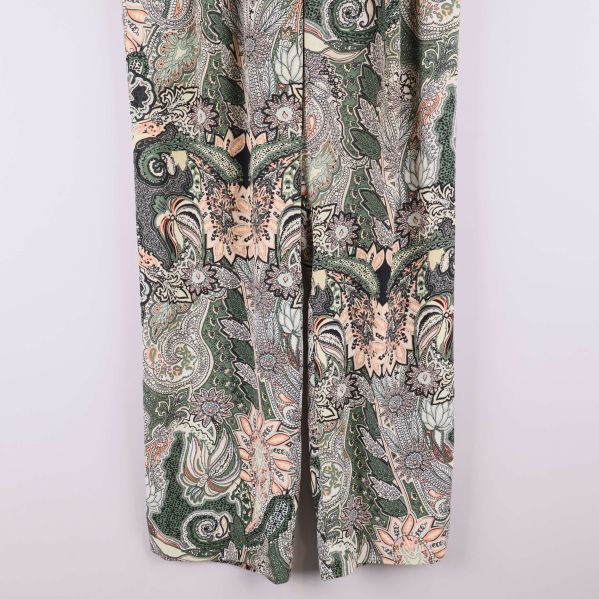 Närbild på byxbenen med paisleymönster och bred passform