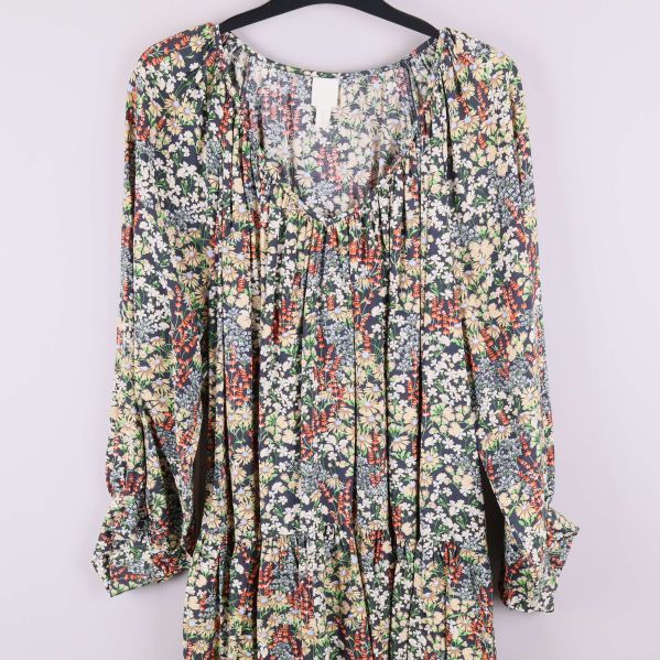 Närbild på överdel av blommig klänning