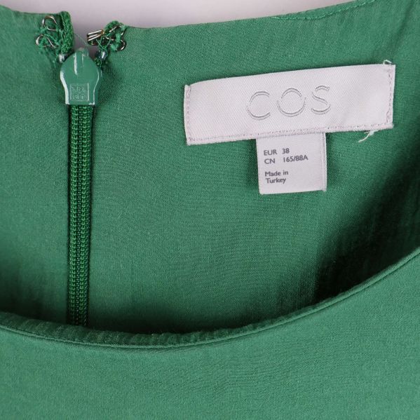 Närbild på COS-etikett och dragkedja i nacken