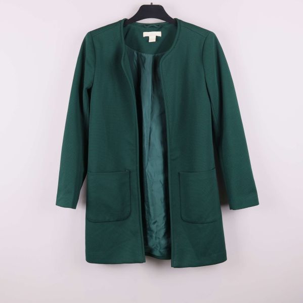 Framsidan av grön strukturerad jacka med fickor