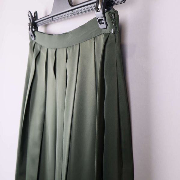 Närbild av midjan och dragkedjan på grön kjol