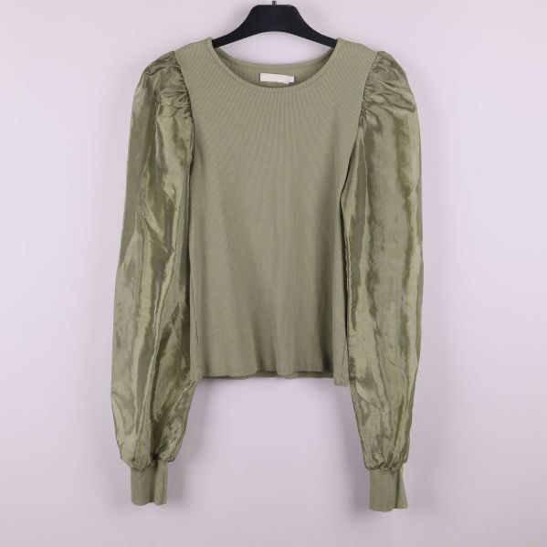 Olivgrön tröja med glansiga ärmar framifrån hängande på galge