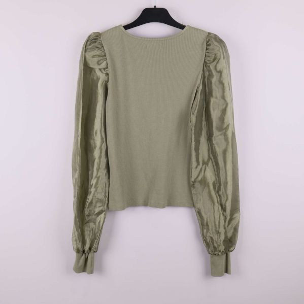 Olivgrön tröja med glansiga ärmar bakifrån på galge