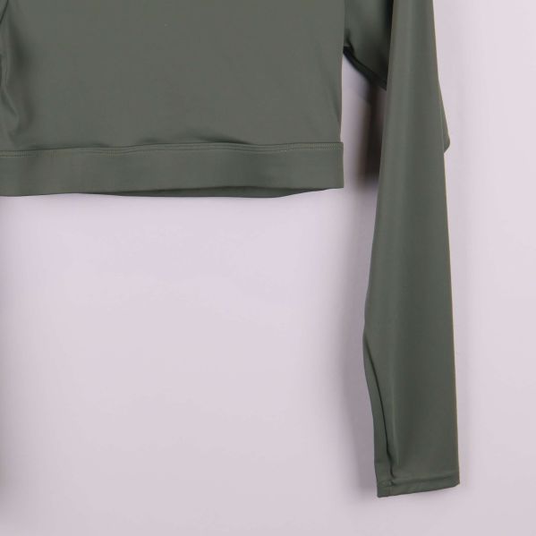 Närbild på ärm och nederkant av grön topp