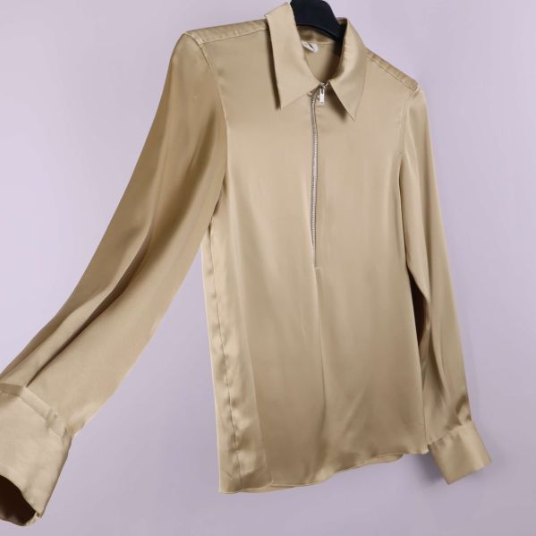 Beige blus visad i vinkel med långa ärmar