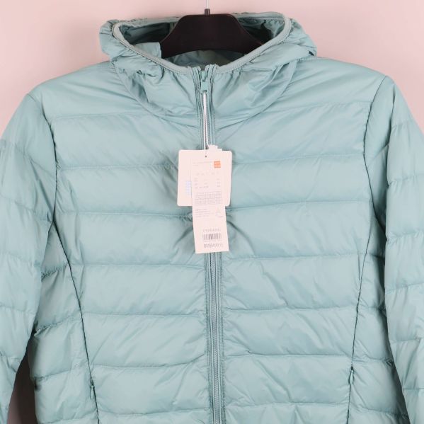 Närbild på huva och dragkedja på ljusblå jacka