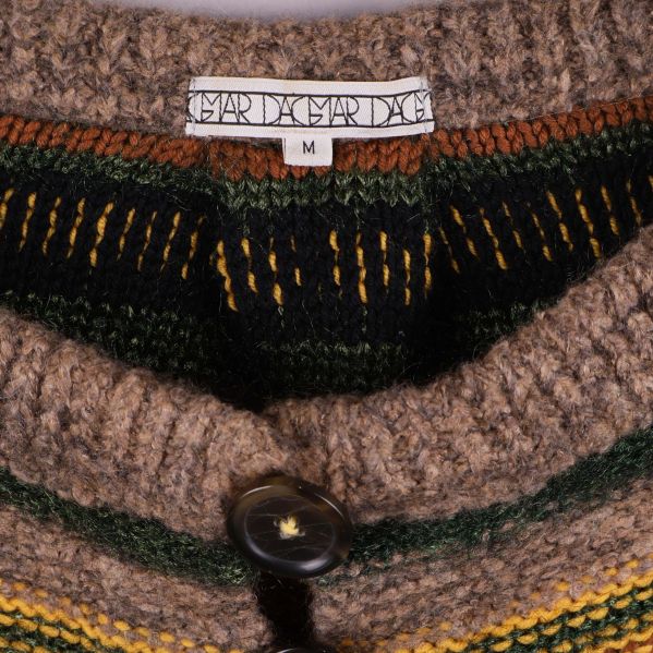 Närbild av etikett Dagmar och storlek M i stickad kofta