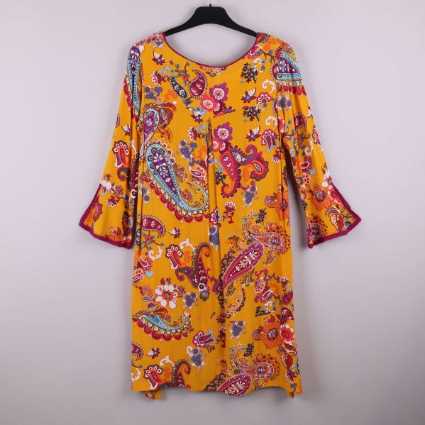 Baksida av gul paisleymönstrad klänning med trumpetärm