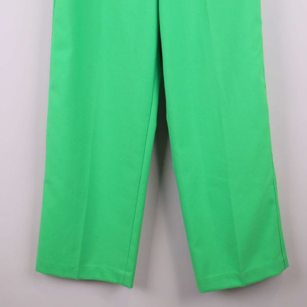 Närbild av benslut på gröna raka byxor