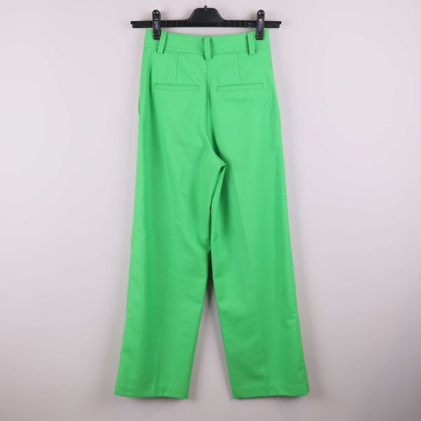 Baksida av gröna raka byxor hängande på galge