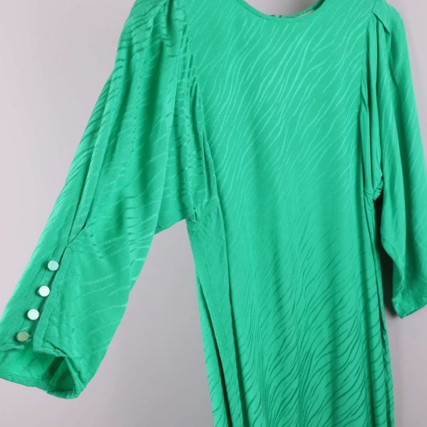 Trekvartsärm med knappar på grön klänning