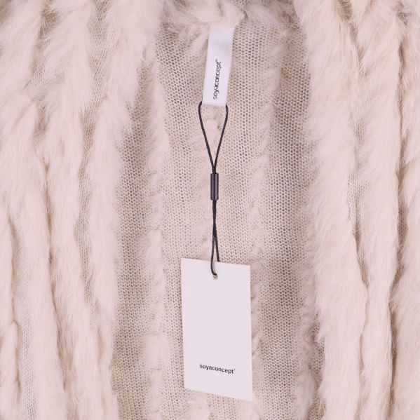 Närbild på etikett och fuskpäls på väst