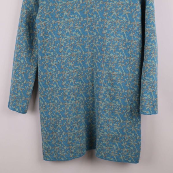 Nedre delen av blåmönstrad klänning visas i närbild
