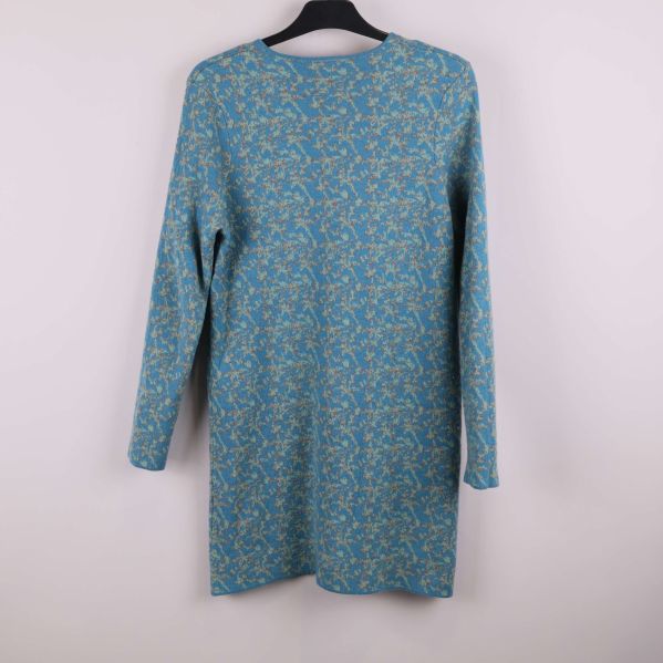 Baksidan av blåmönstrad klänning med långa ärmar