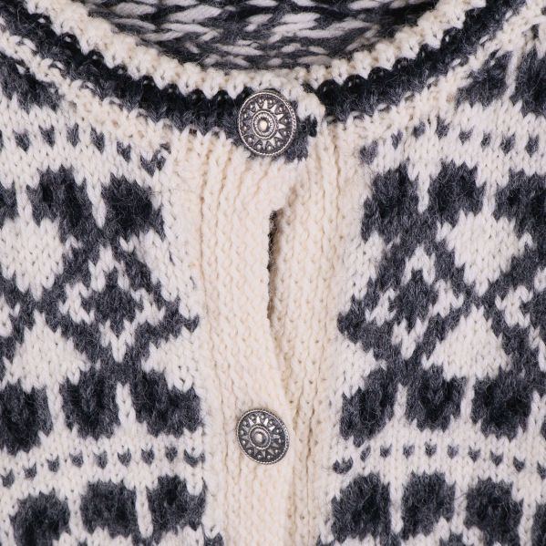 Närbild på knäppning och mönster vid halsen på kofta