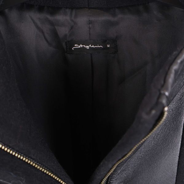 Närbild på etikett med Shafira-märke inuti kappan