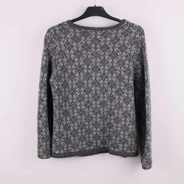 Baksida av grå jacquardmönstrad kofta på galge