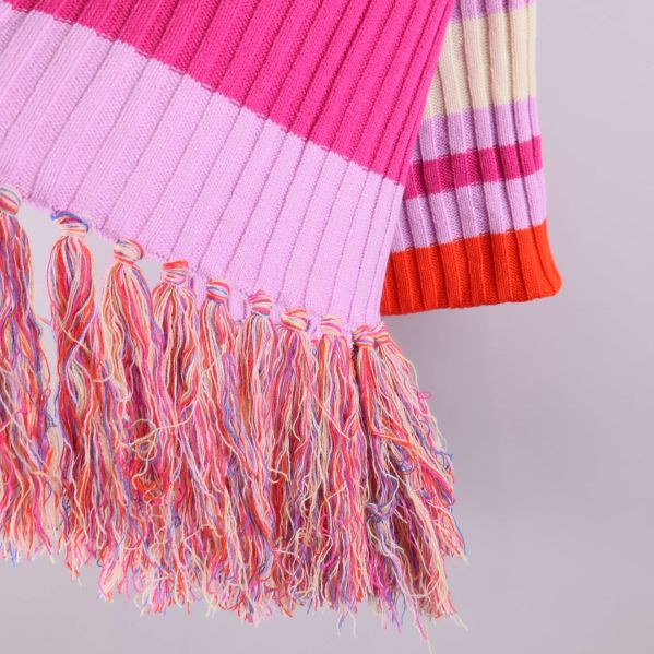 Närbild på flerfärgade fransar och stickat mönster