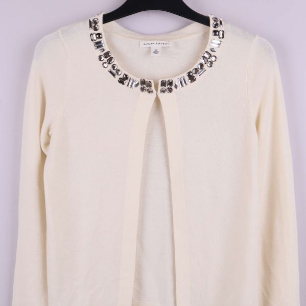 Kofta med dekorativa stenar kring halsen fotograferad framifrån