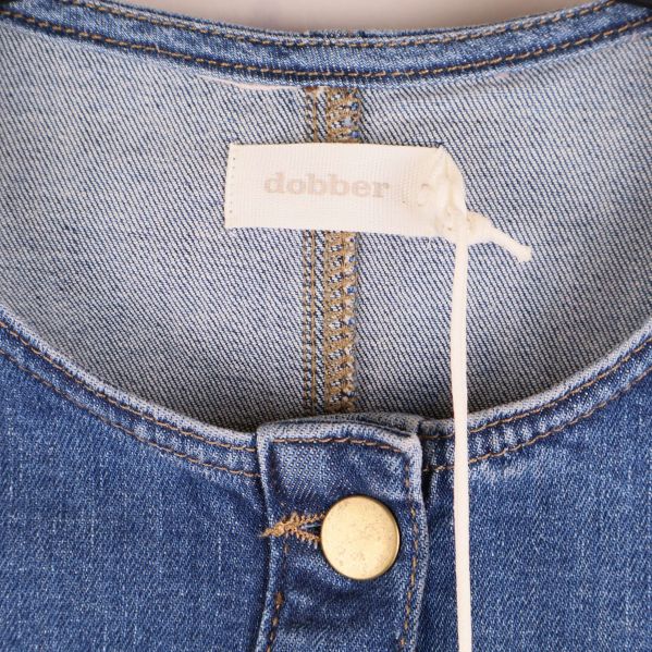 Halsringning och etikett i nacken på jeansklänning