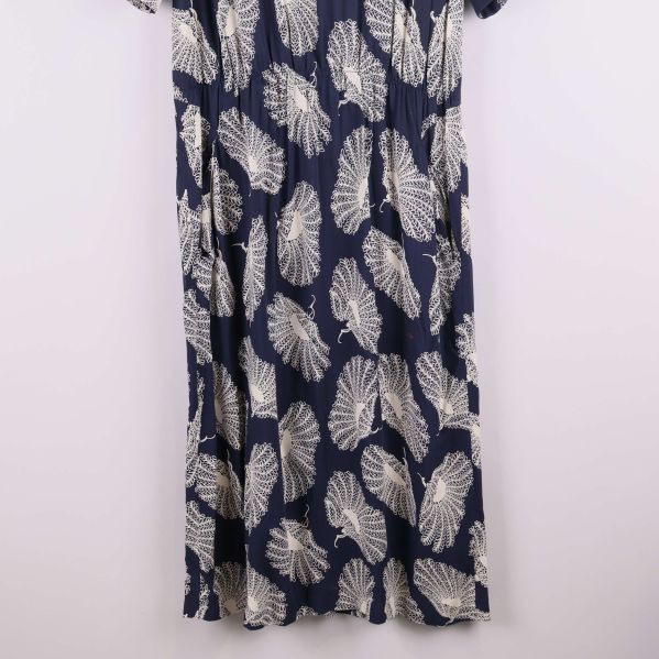 Nedre delen av klänning med vitt bladlikt mönster