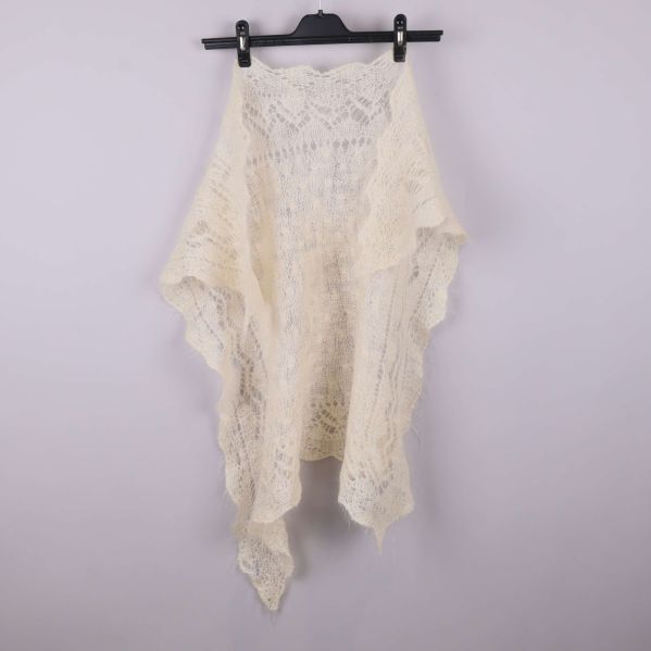 Ljus spetsstickad sjal utfälld i helfigur på galge