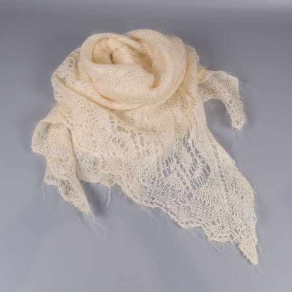 Ljus spetsstickad sjal draperad i cirkel på ett bord