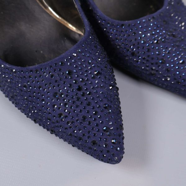 Närbild på mörkblå strass och spetsig tå på pumps