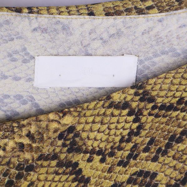 Närbild på etikett samt insida vid halsen av klänningen