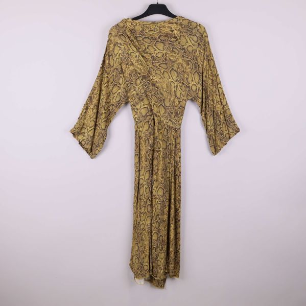 Baksidan av lång klänning med ormmönster och vida ärmar