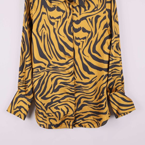 Detaljbild på skjortans nederdel och manschetter