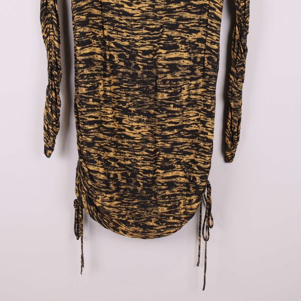 Dragsko och detalj av klännings nederkant, svart och gult tyg