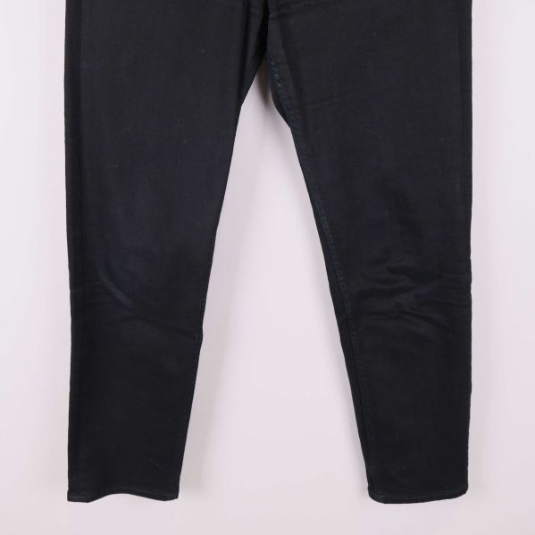 Närbild på benen av svarta jeans utan synlig dekoration