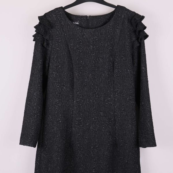 Närbild på klänningens övre del och axeldetaljer